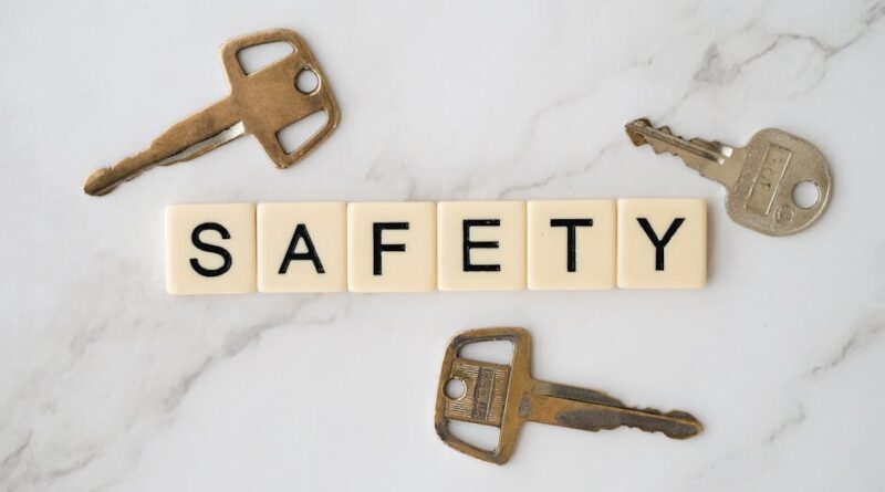Close-up image of keys and scrabble tiles spelling 'safety' on a marble surface.
