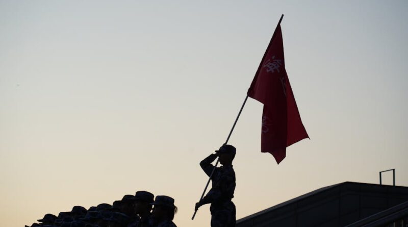 A soldier salutes with a flag during a parade at sunset, creating a striking silhouette.