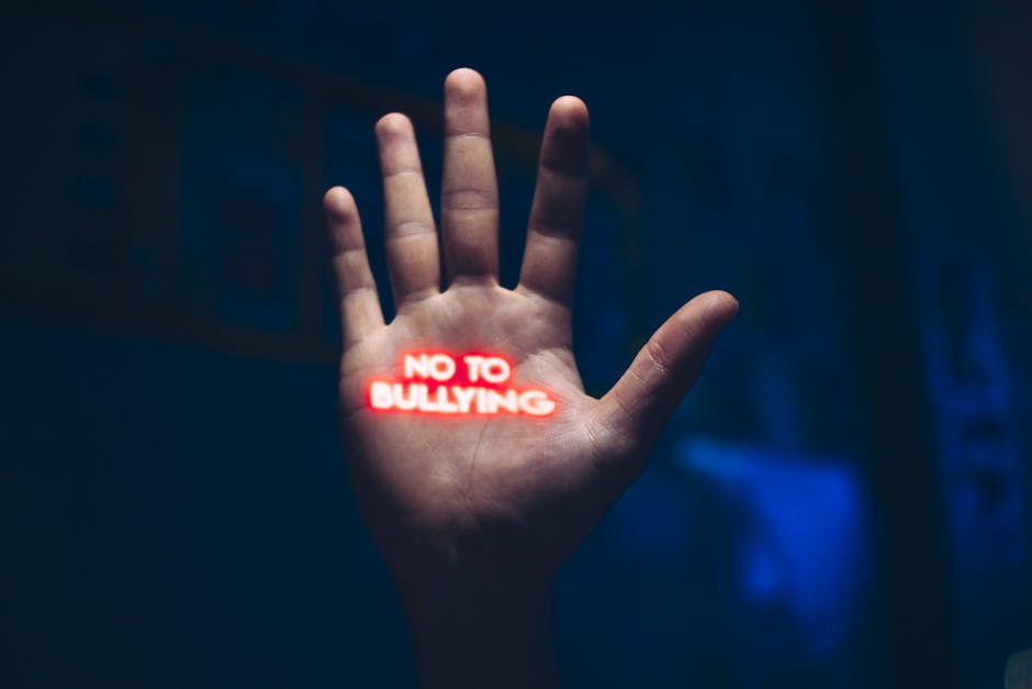 A hand with a glowing 'No to Bullying' message, highlighting bullying awareness.