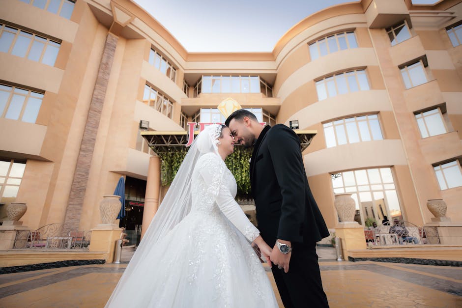 Bride and groom share a moment at an elegant outdoor wedding venue with modern architecture.