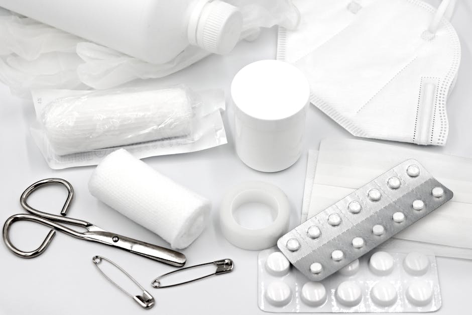 A flat lay of essential first aid supplies and medical equipment on a white background.