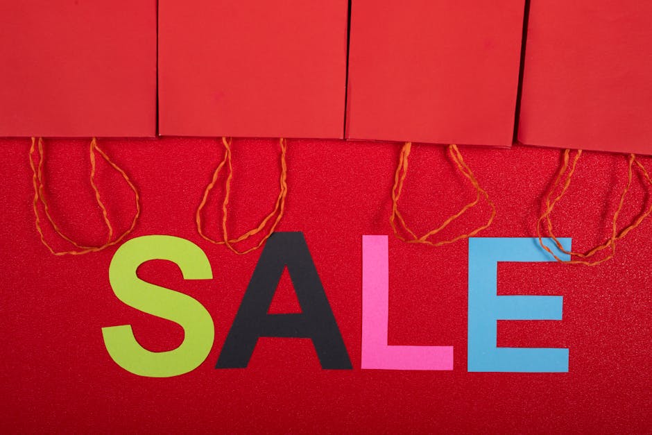 Colorful sale sign with red shopping bags for retail promotions.