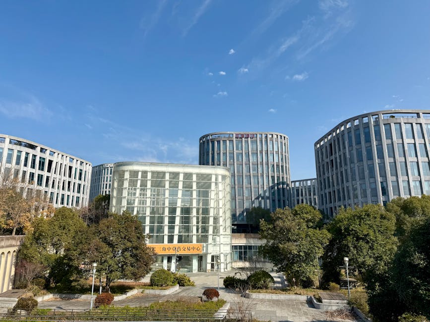 Contemporary office buildings framed by lush greenery in sunny Zhangjiang, Shanghai.