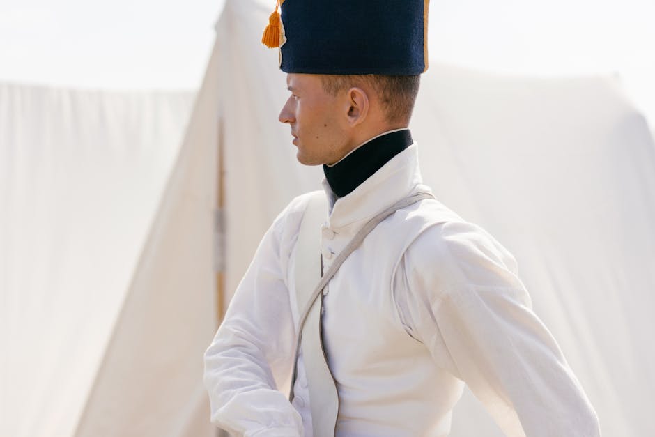 Profile portrait of a soldier in historical uniform during a military reenactment in a tent camp.