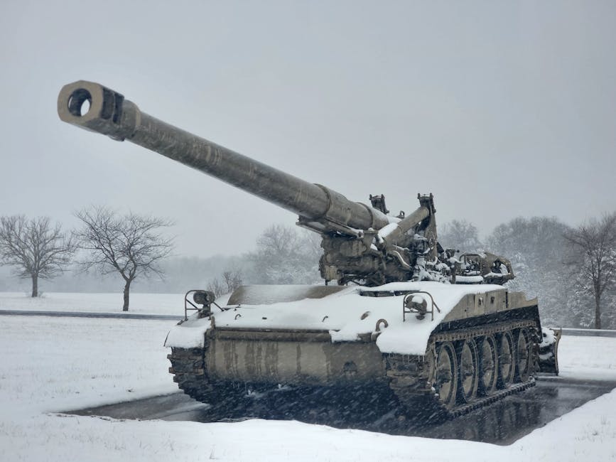 A snow-covered tank sits on a winter battlefield, surrounded by trees in Monett, MO.
