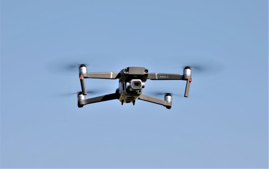 Close-up of a modern drone flying against a clear blue sky, showcasing advanced technology.