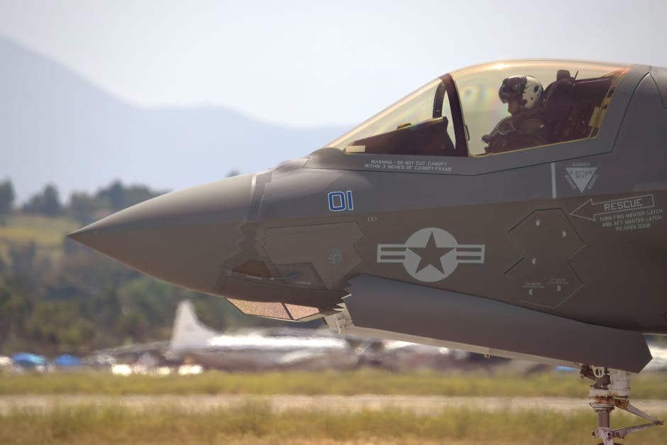 Close-up of a military fighter jet with pilot on a runway, equipped for action.